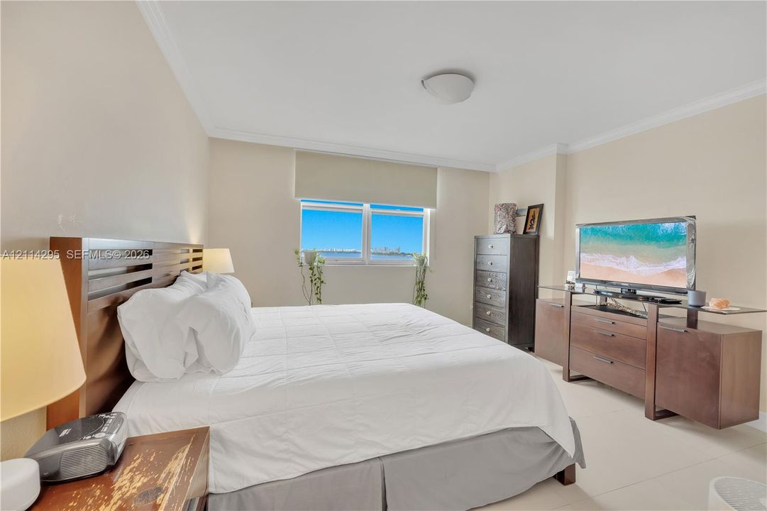 Bedroom featuring neutral wall paint, crown molding, a semi-flush mount ceiling fixture, and a large window with horizontal blinds