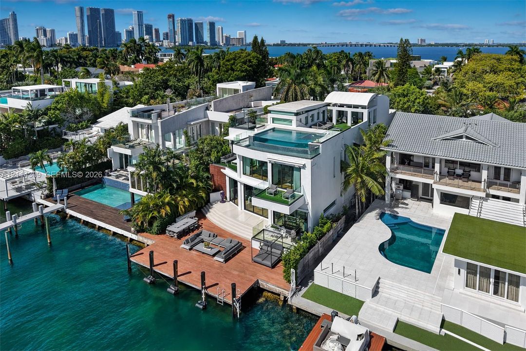 Waterfront property featuring a rooftop infinity-edge pool, multi-level terraces, integrated glass railings, and private deep-water dockage