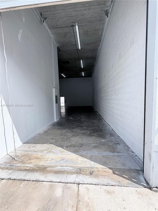 Industrial space featuring high ceilings, concrete flooring, exposed masonry walls, and linear overhead lighting