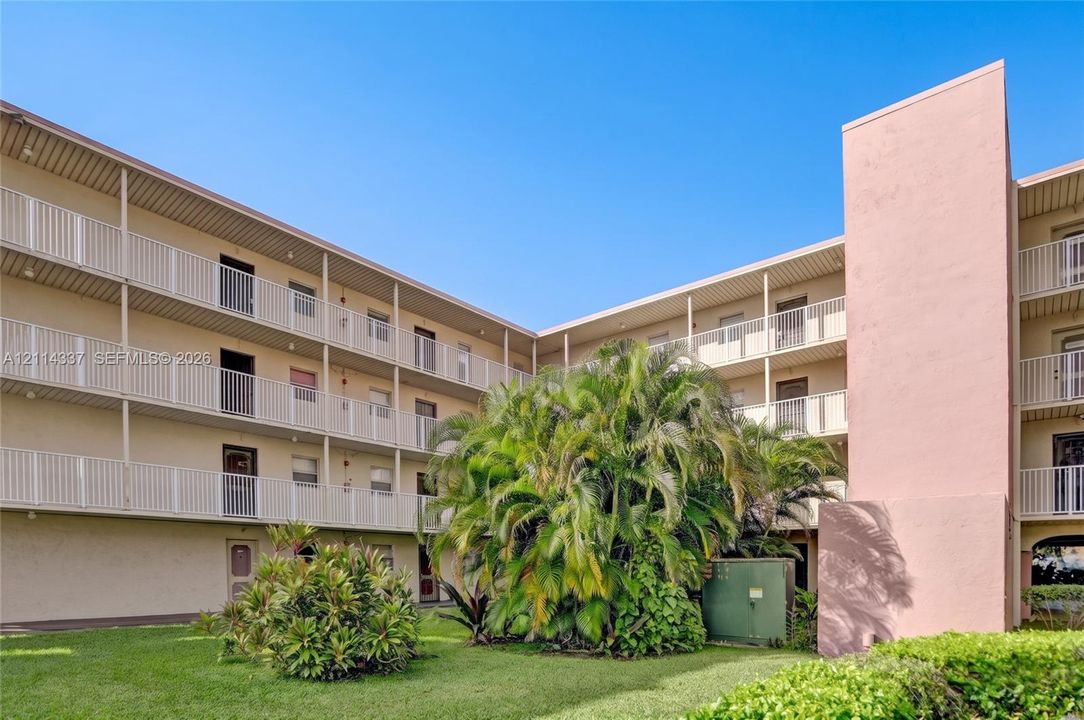 Brookfield Square Condo exterior featuring mature landscaping, paved surface parking, and multi-story structural architecture