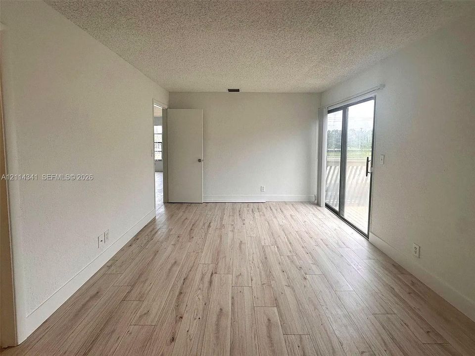 Interior space featuring wood-finish flooring, sliding glass door, and neutral wall tones