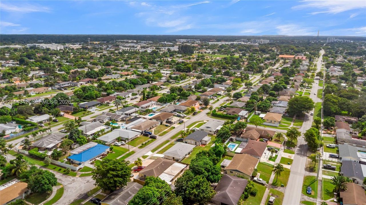Aerial perspective of the residential area featuring a grid-pattern street layout, mature tree canopy, and established landscaping