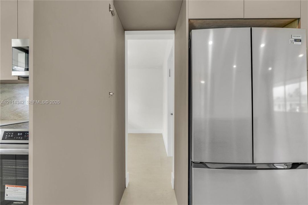 Kitchen featuring stainless steel refrigerator, integrated cabinetry, and built-in microwave