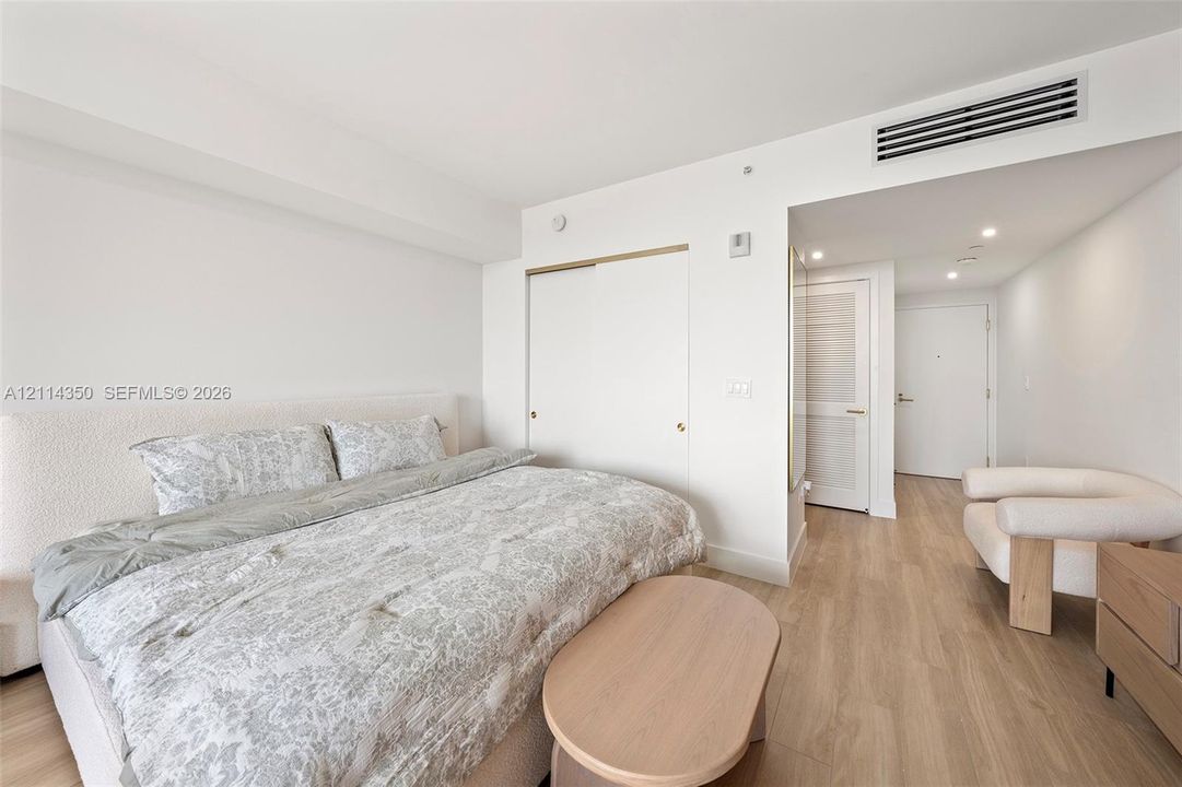 Wood-finish flooring, sliding door closet, recessed lighting, and wall-mounted climate control