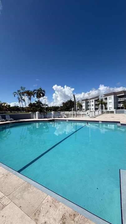 In-ground swimming pool featuring a tile perimeter and stone-paver decking