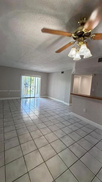 Ceramic tile flooring, sliding glass door, and ceiling fan with integrated light fixture