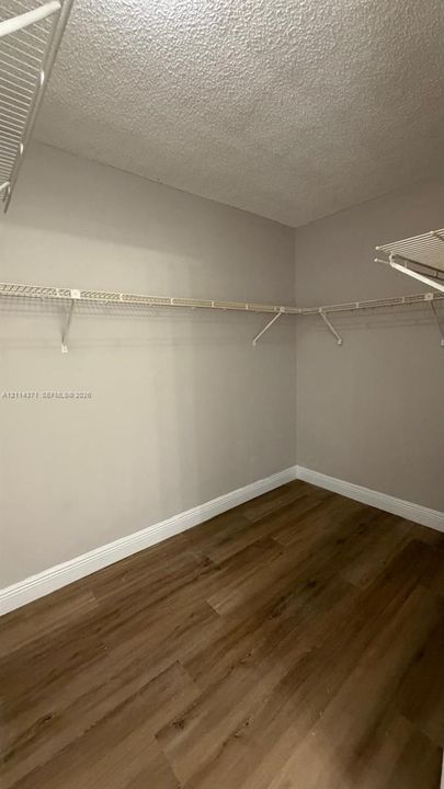 Storage space featuring wood-finish flooring and installed wire shelving