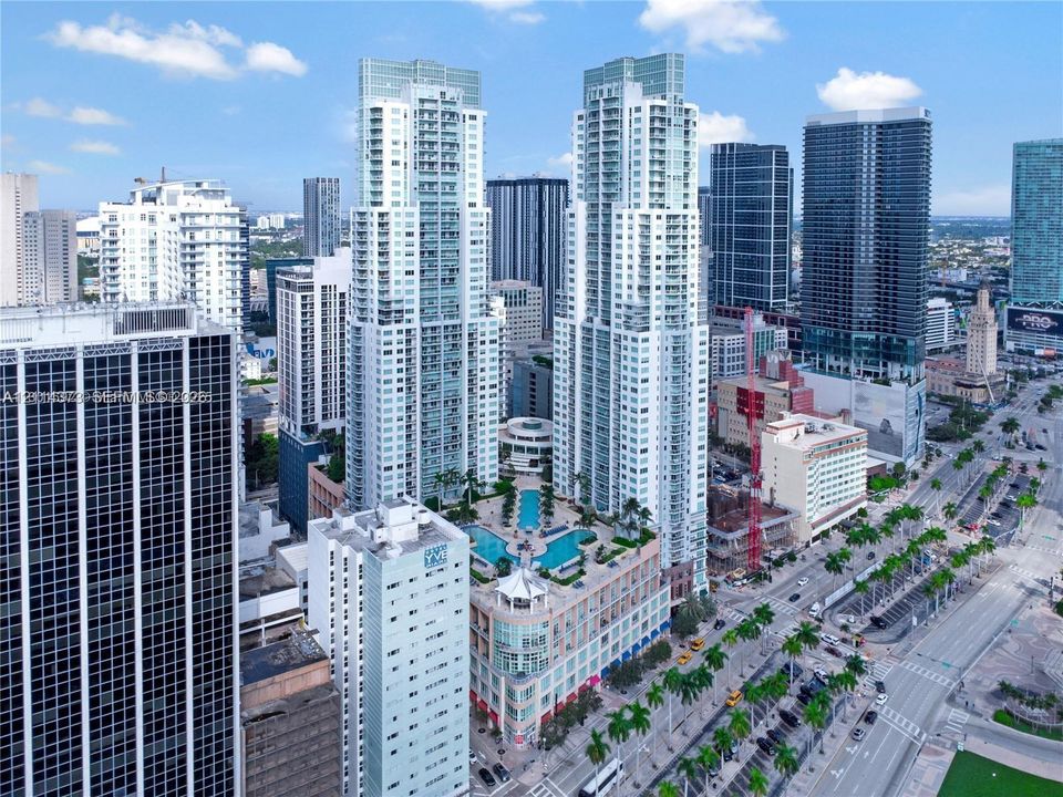 High-rise residential towers featuring glass facades, an elevated outdoor pool deck, and integrated multi-level parking podiums