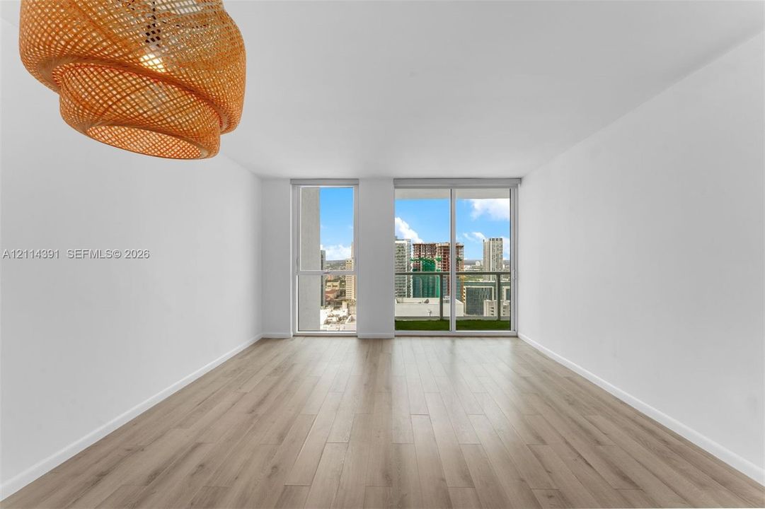 Wood-finish flooring, floor-to-ceiling windows, sliding glass door, glass-paneled balcony, and textured pendant lighting fixture