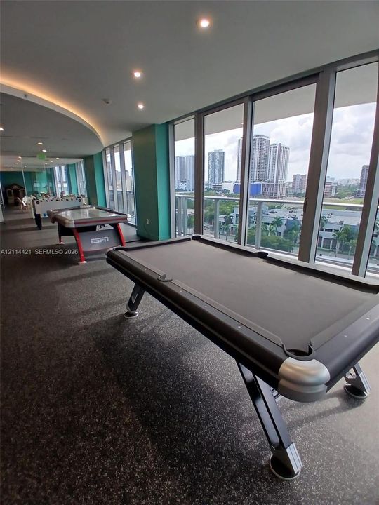 Floor-to-ceiling windows with metal framing, recessed ceiling lighting, cove lighting, and textured flooring