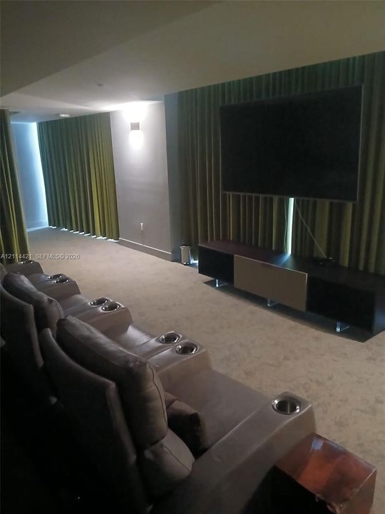 Wall-mounted lighting fixtures, floor-to-ceiling drapery, and neutral carpeting