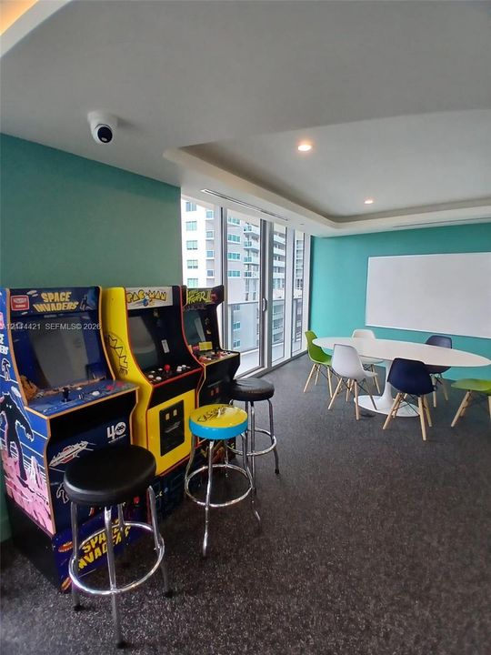 Recessed ceiling lighting, floor-to-ceiling windows, and wall-mounted dry-erase board