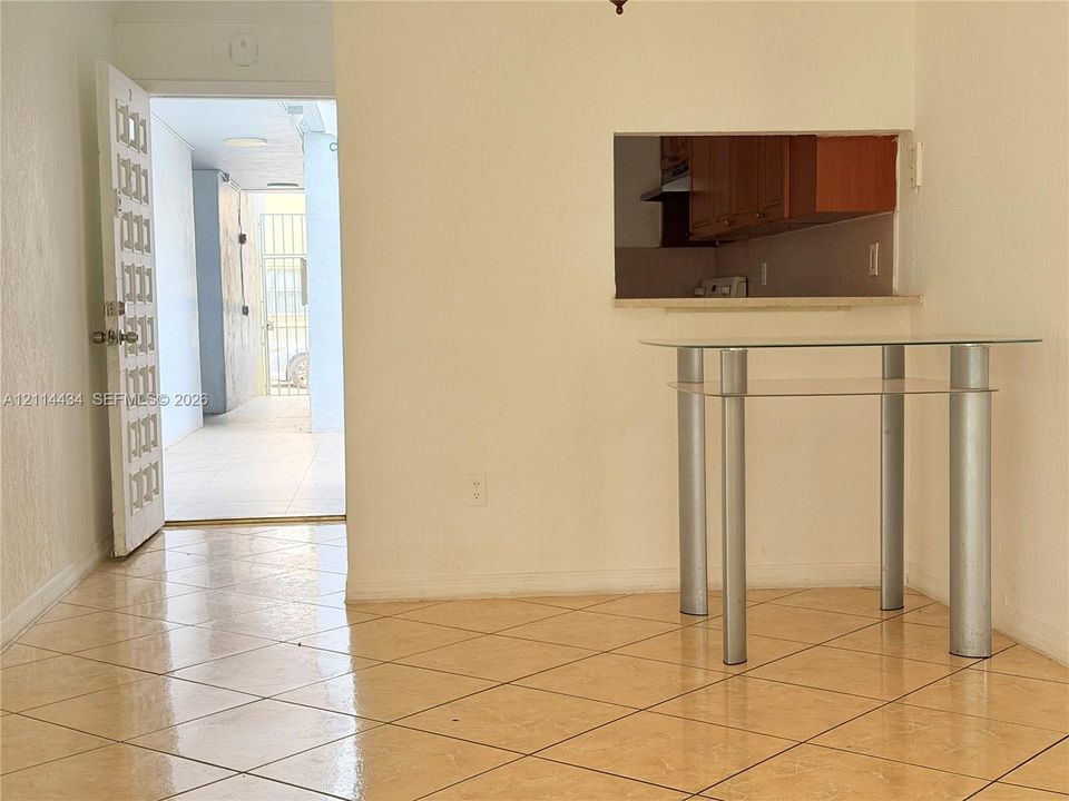 Interior space featuring neutral wall tones, large-format diagonal tile flooring, and floor-to-ceiling vertical blinds