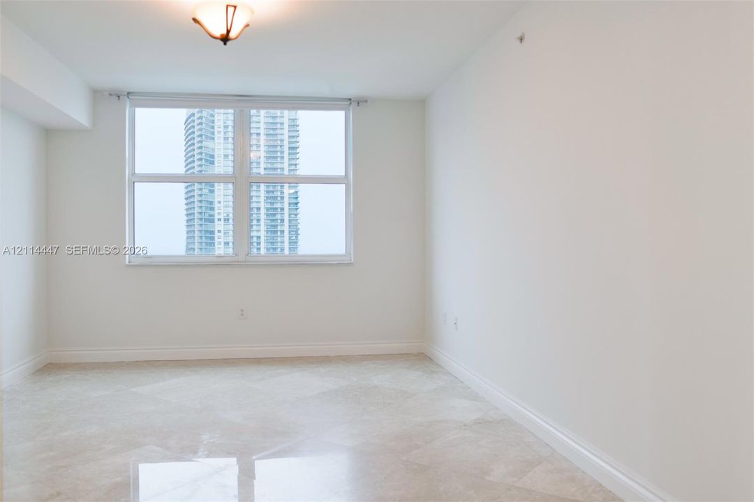 Large-format tile flooring, neutral wall tones, and oversized window featuring urban architecture