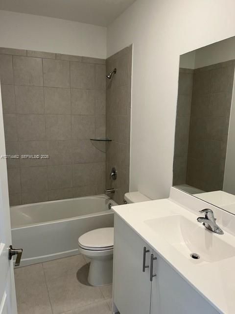 White vanity with integrated sink, rectangular wall-mounted mirror, ceramic tile shower surround, glass corner shelf, and polished chrome fixtures