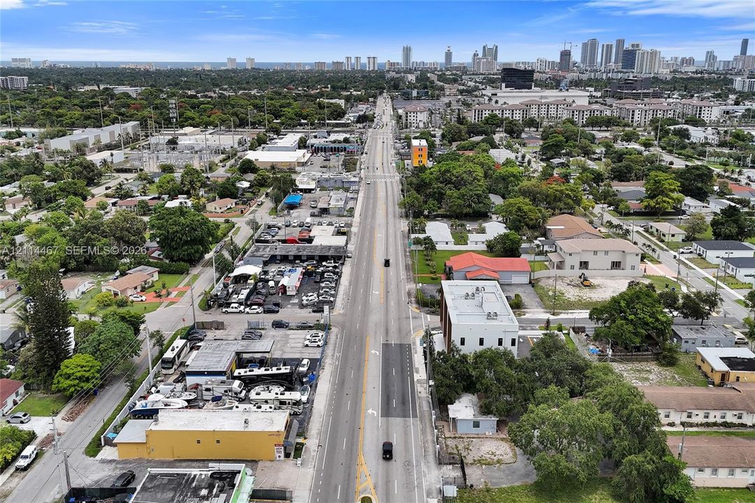 Aerial perspective featuring proximity to a metropolitan skyline, major thoroughfare access, and a surrounding mix of commercial and residential infrastructure