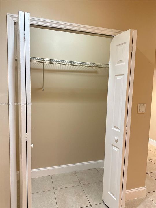 Reach-in closet featuring white bi-fold doors and built-in wire shelving