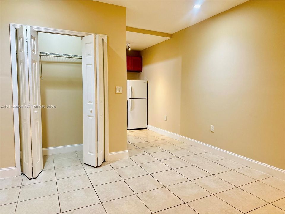 Ceramic tile flooring, white bifold closet doors with wire shelving, and recessed ceiling lighting