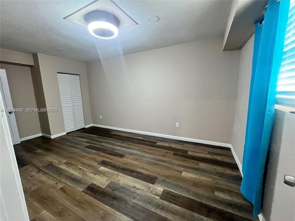 Room featuring wood-finish flooring, recessed lighting, and louvered closet doors