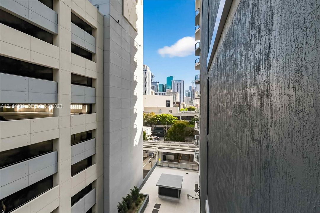 Urban skyline landscape featuring textured charcoal-colored exterior siding, light-toned concrete structural facade, and tiered high-rise architecture