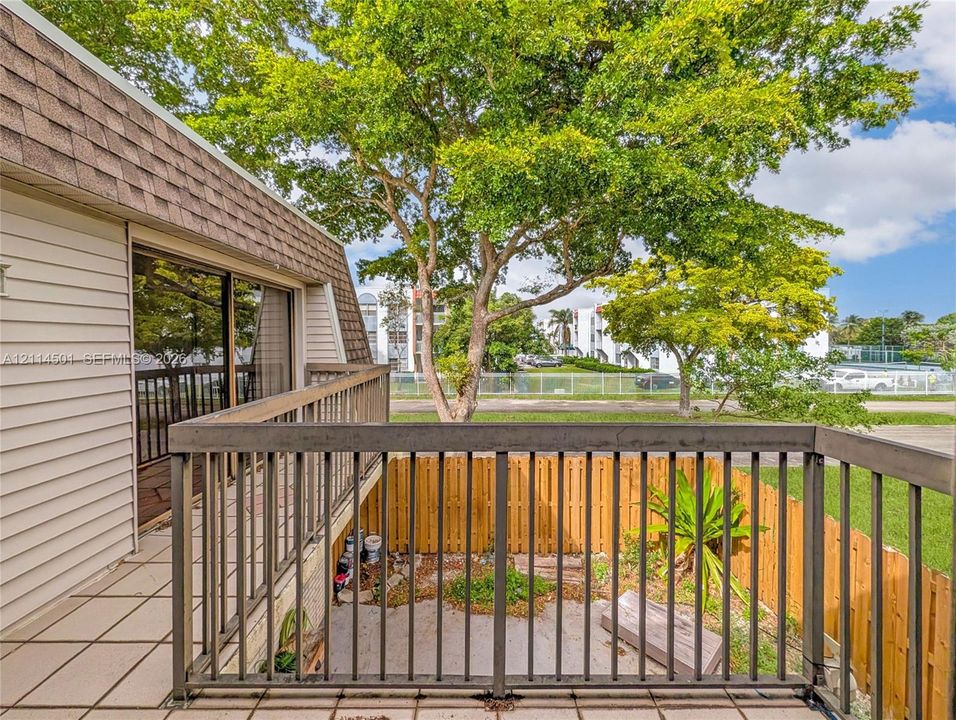 Private balcony with metal railing, tile flooring, and integrated sliding glass doors