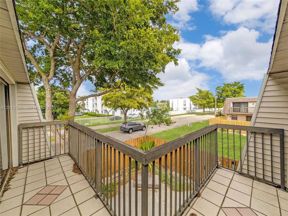 Second-level balcony featuring patterned tile flooring and dark-finish metal railings