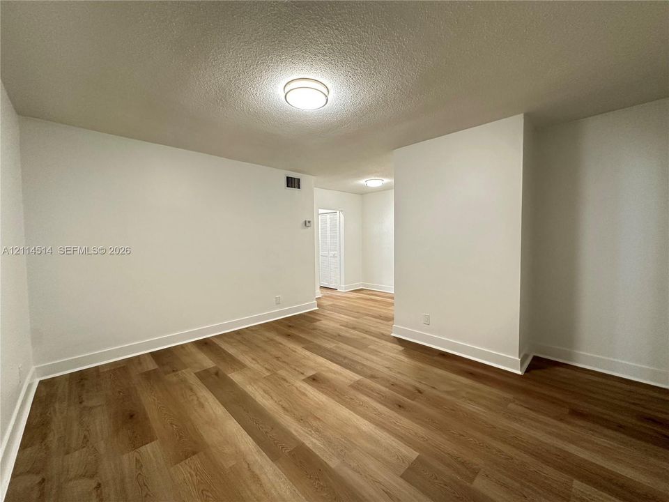 Interior space featuring wood-finish flooring, white walls, and flush-mount ceiling lighting