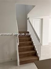 Staircase featuring wood-finish treads and white balustrades