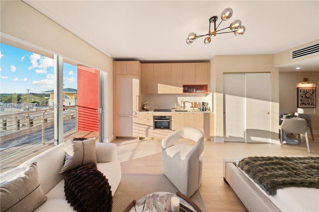 Open-concept living space featuring floor-to-ceiling glass sliding doors, light-toned cabinetry, integrated kitchen appliances, wood-finish flooring, and a multi-arm modern light fixture
