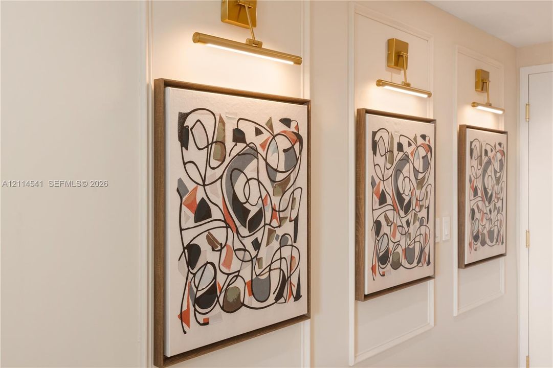 Wall-mounted gold-tone linear sconces featuring panel molding and decorative wall trim