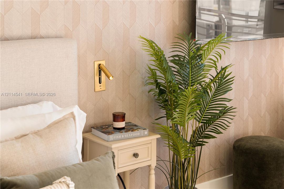 Textured wall treatment featuring a geometric pattern and a brass-finish wall-mounted reading light