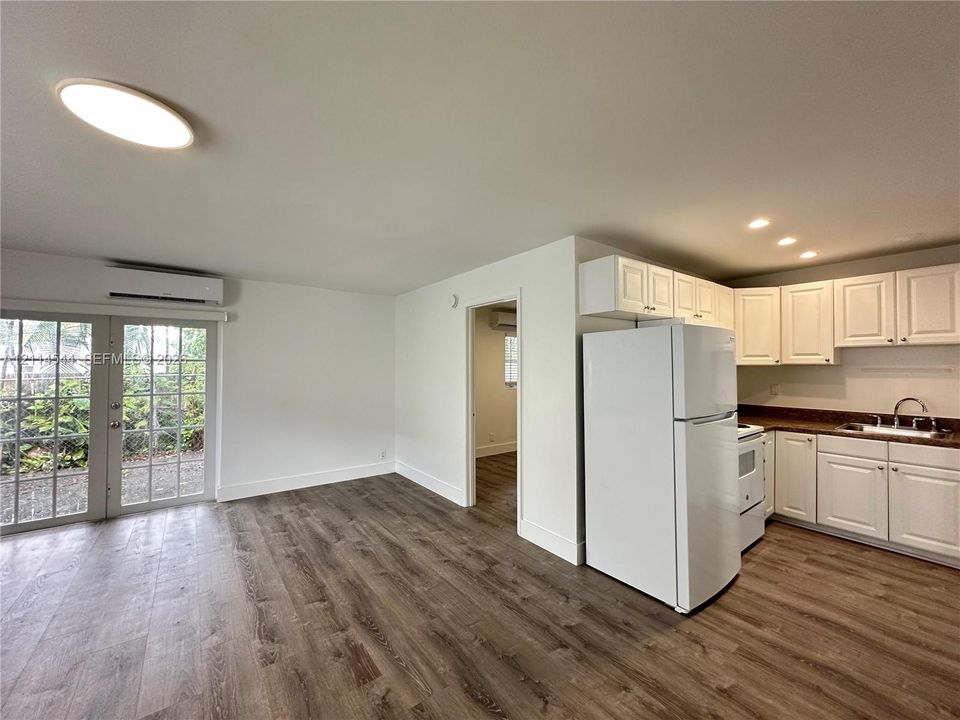 Kitchen featuring white shaker-style cabinetry, wood-finish flooring, recessed lighting, and a glass-paneled exterior door