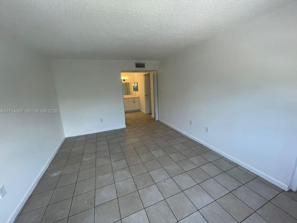Neutral-toned tile flooring throughout the interior, featuring crisp white wall finishes