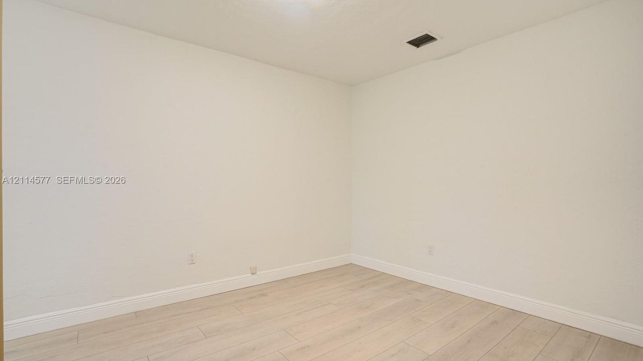 Neutral-toned interior space featuring light-colored wood-finish flooring and smooth wall surfaces