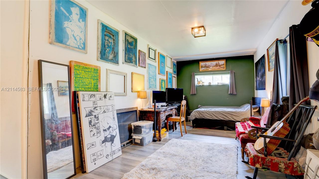 Room featuring wood-finish flooring, a horizontal transom window, and a contrasting accent wall