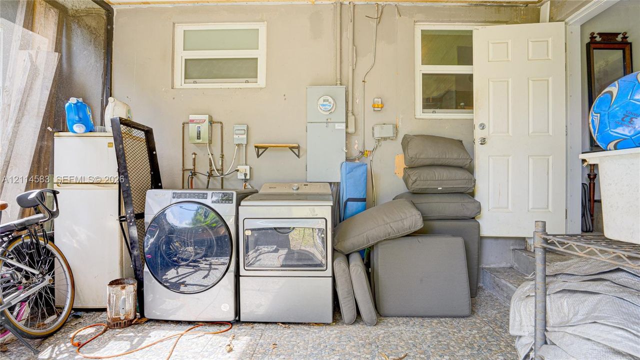 Laundry area featuring dedicated water hookups, dual windows, and an exterior door