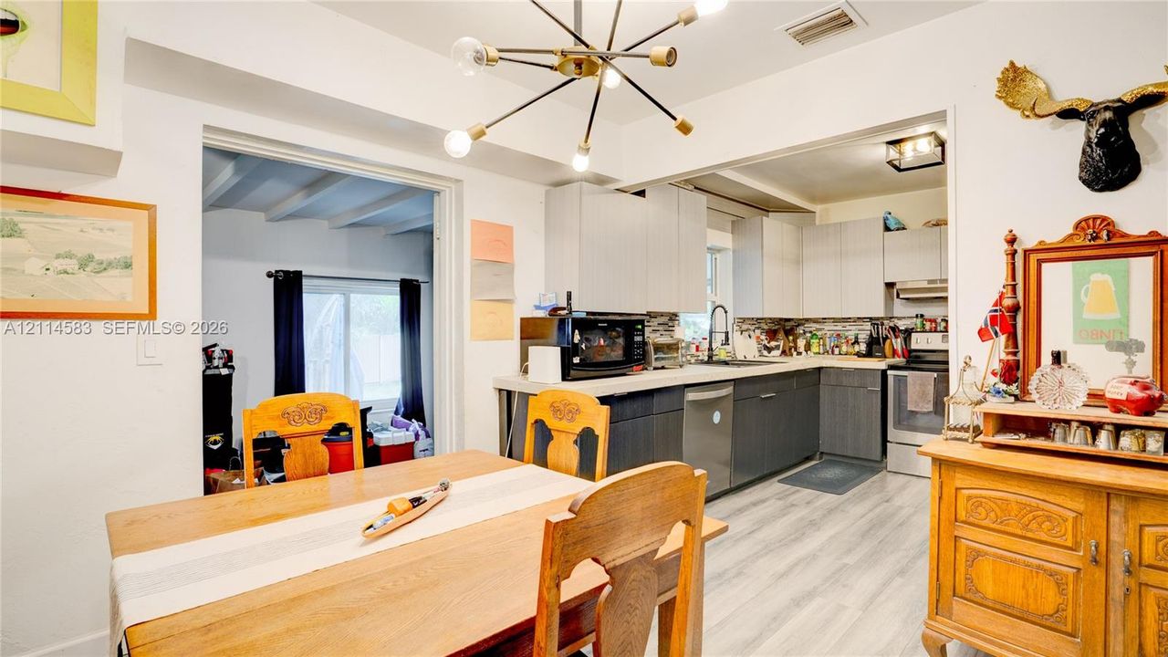 Kitchen featuring two-toned cabinetry, light-toned countertop, wood-finish flooring, and a multi-arm sputnik-style light fixture