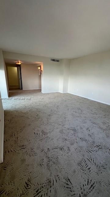 Neutral-toned interior featuring patterned carpeting and dual-mounted light fixtures