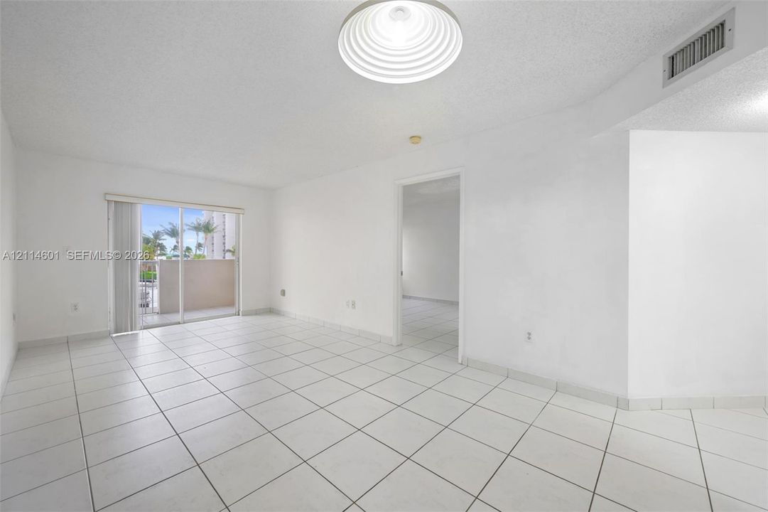 Interior space featuring large-format ceramic floor tiles, recessed ceiling lighting, and sliding glass doors with exterior patio access