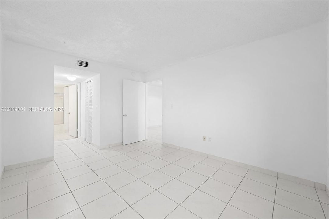 Interior space featuring large-format ceramic tile flooring, solid-core interior doors, and neutral wall finishes