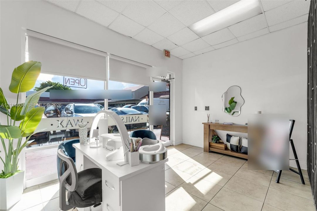 Commercial space featuring floor-to-ceiling storefront windows, tile flooring, and drop ceiling panels