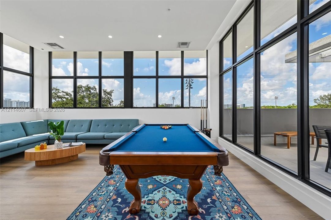 Fitness area featuring painted concrete block walls, durable rubberized flooring, an exposed ceiling structure, and floor-to-ceiling glass paneling with an exterior door