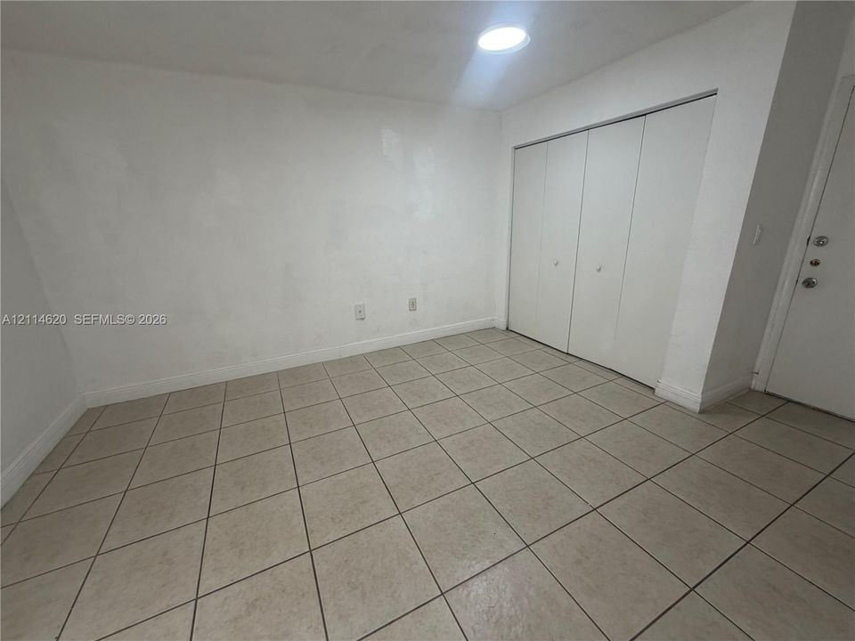 Room featuring ceramic tile flooring, a multi-panel closet with dual doors, and a ceiling-mounted recessed light