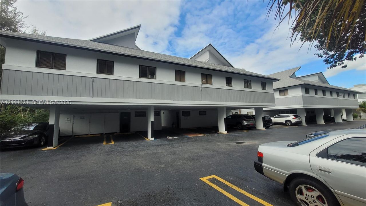 Multi-level exterior featuring a combination of light-toned siding and vertical plank paneling, dual-pitched rooflines, and covered ground-level parking