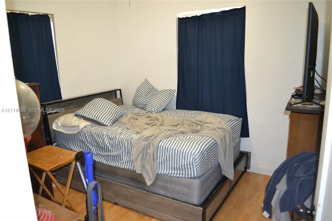 Interior room featuring light wood-finish flooring and two windows