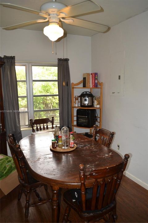 Multi-pane window with wood-finish flooring and a central ceiling fan with integrated lighting