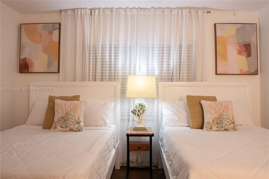 Interior space featuring a window with horizontal blinds and floor-to-ceiling drapery