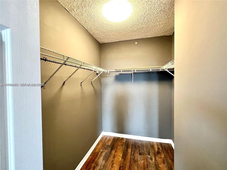 Storage space featuring wood-finish flooring and integrated wire shelving