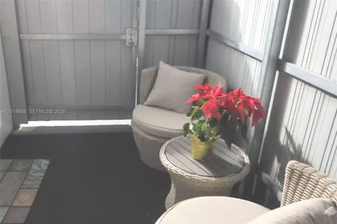 Private outdoor space featuring vertical ribbed metal wall panels and a metal security gate