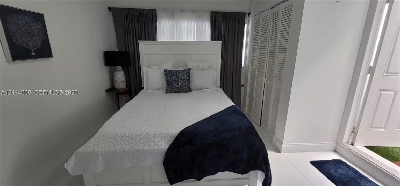 Louvered bi-fold closet doors and neutral tile flooring